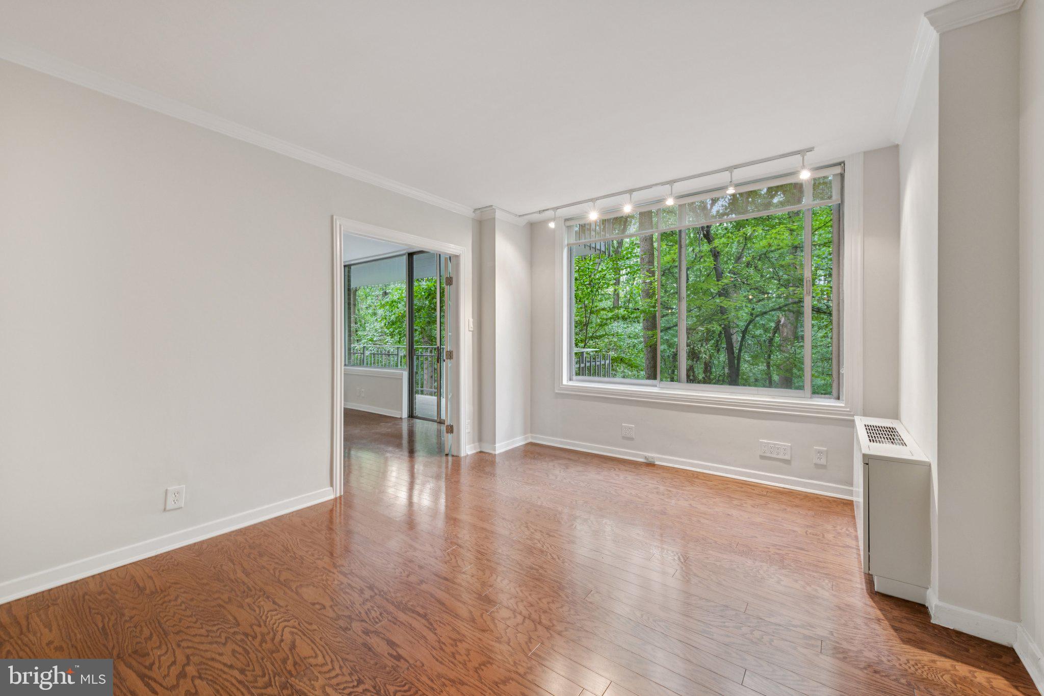 4100 Cathedral Avenue Northwest, Unit 406 Washington, DC 20016 - Photo 15 of 30 a view of an empty room with wooden floor and a window