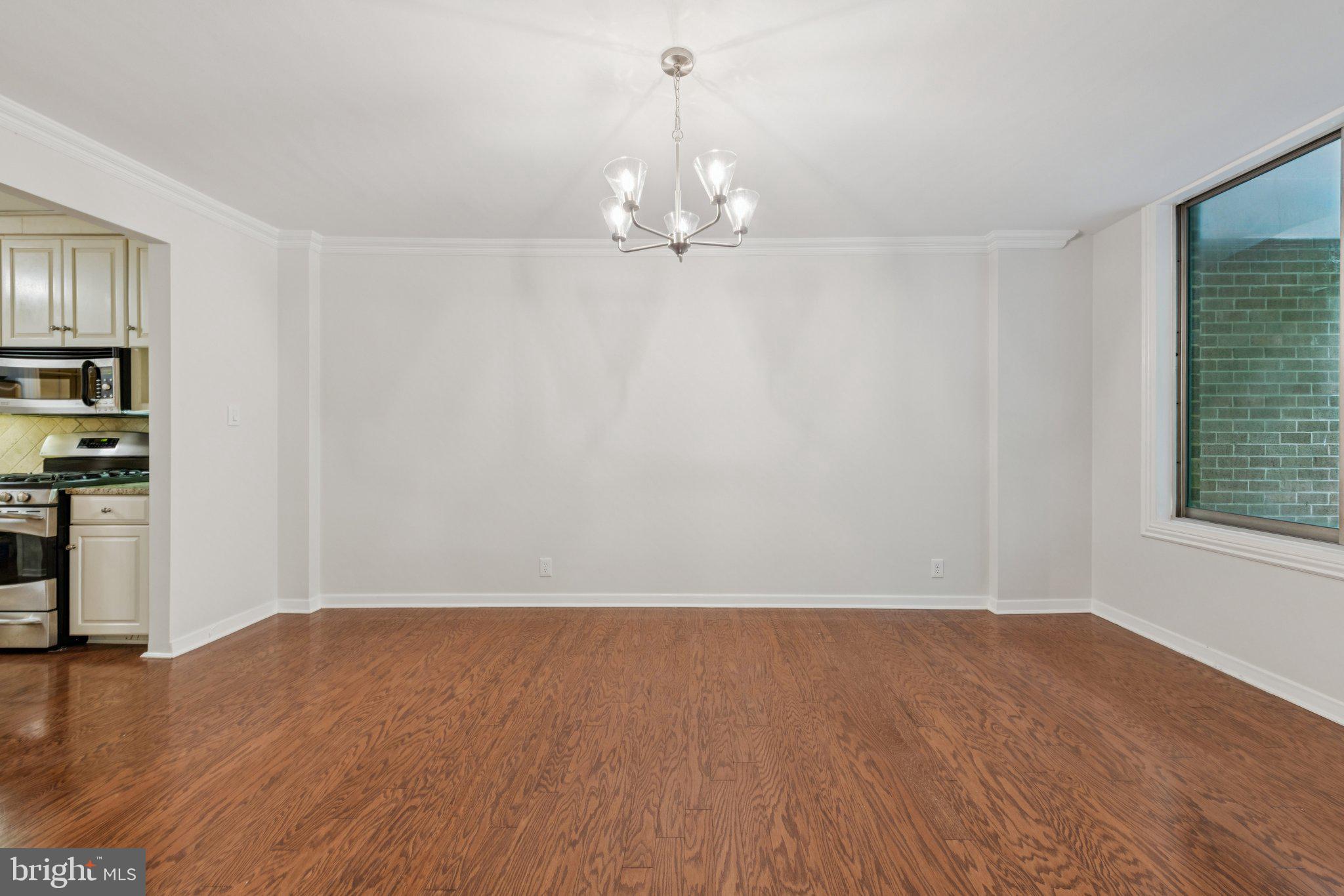 4100 Cathedral Avenue Northwest, Unit 406 Washington, DC 20016 - Photo 4 of 30 wooden floor in an empty room with a window