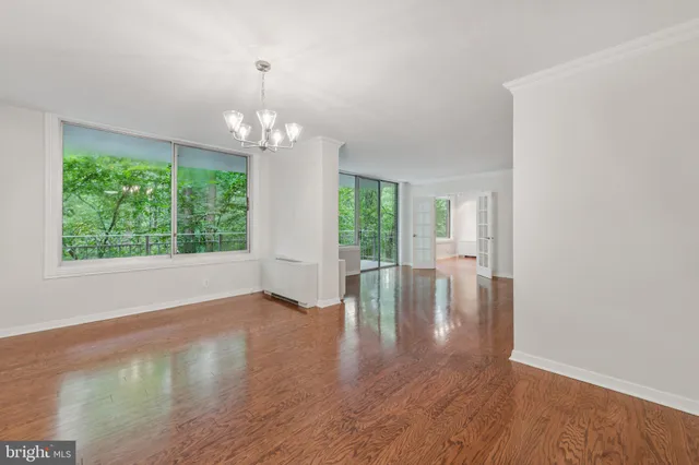 a view of a livingroom with a large window wooden floor and front door