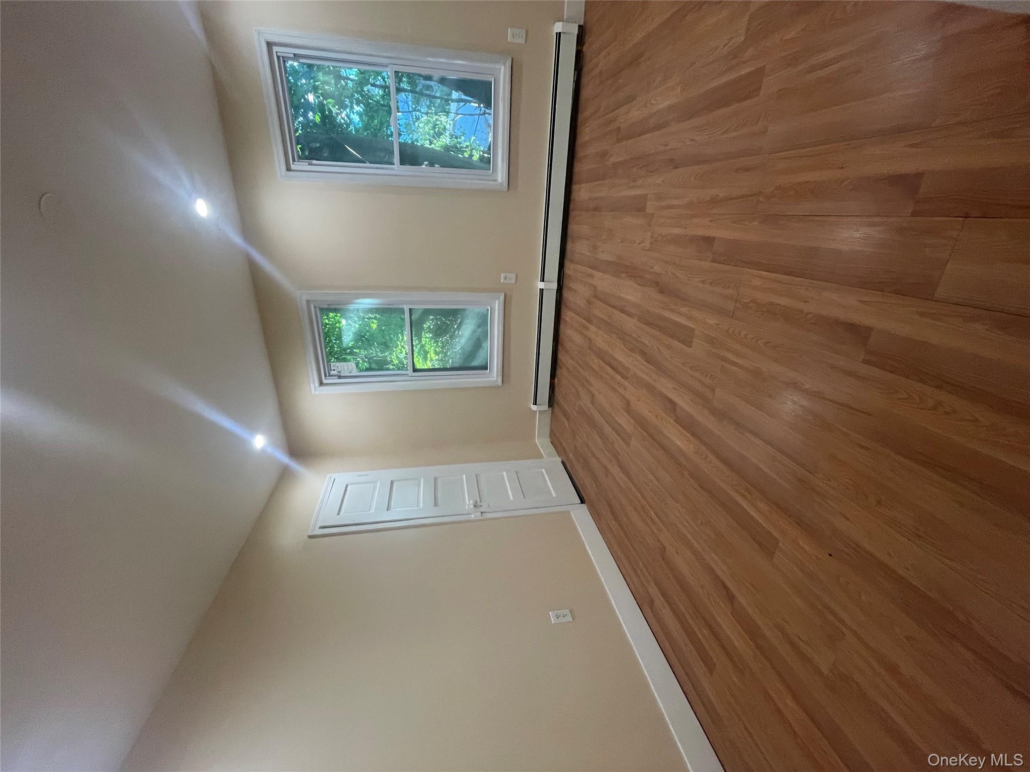 27 Poplar Street, Unit 1 Waterbury, CT 06708 - Photo 2 of 6 a view of an empty room with wooden floor and a window