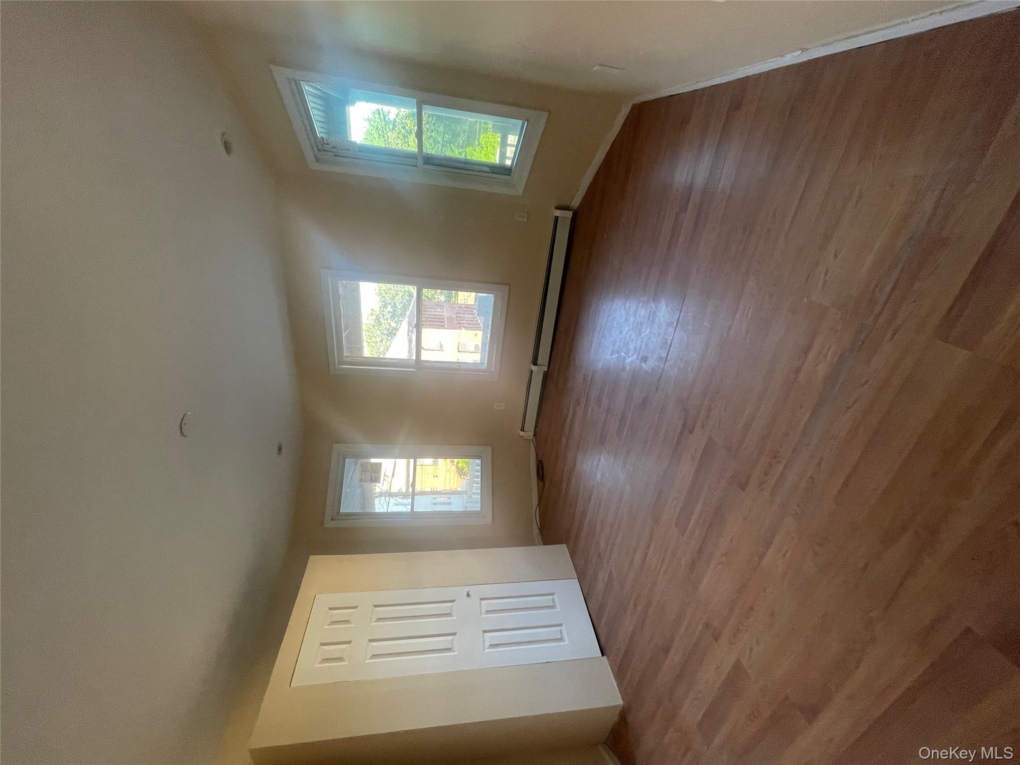 27 Poplar Street, Unit 1 Waterbury, CT 06708 - Photo 3 of 6 an empty room with wooden floor and windows