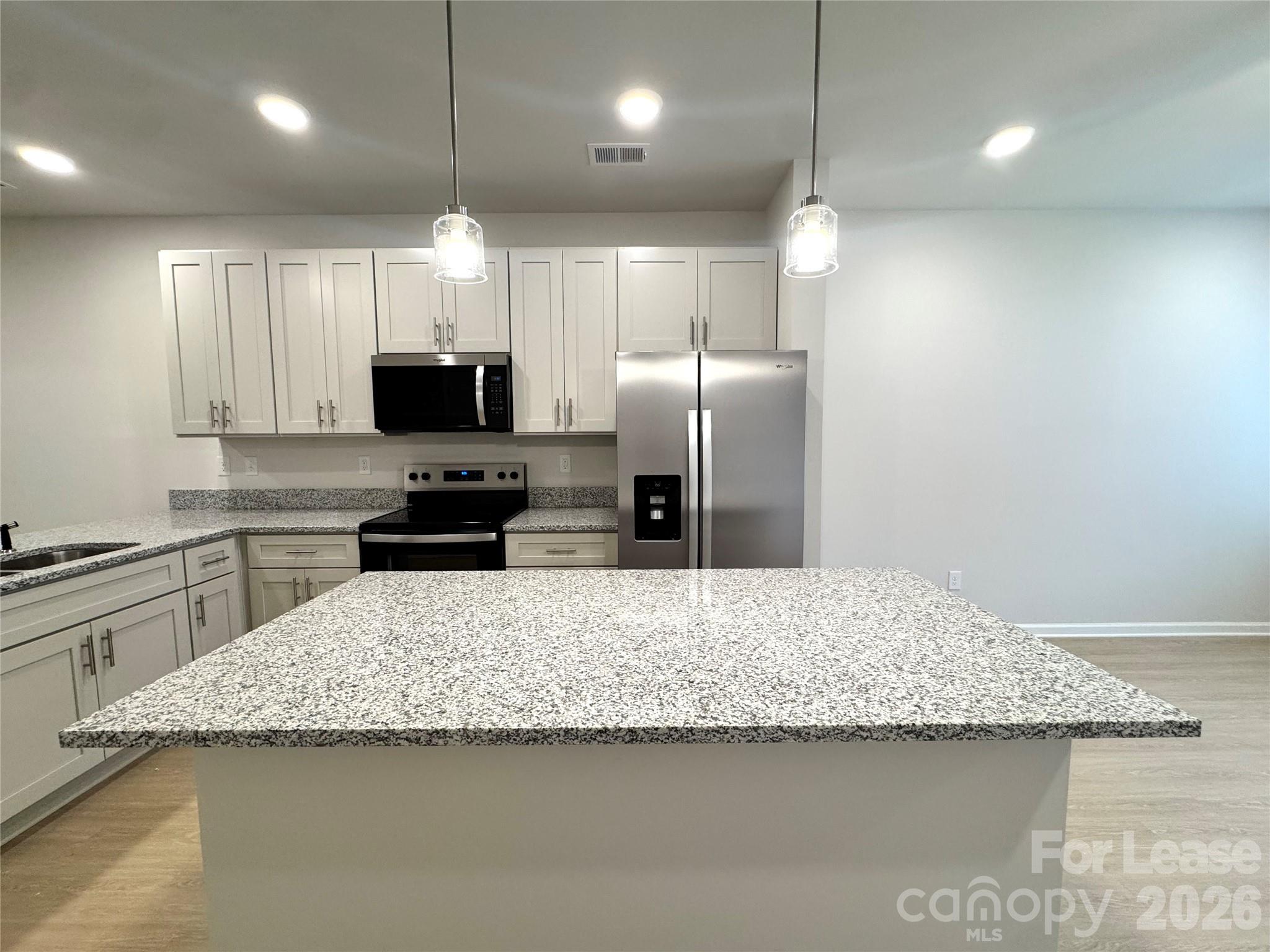4700 Prosperity Church Road, Unit 6409 Charlotte, NC 28269 - Photo 6 of 23 a kitchen with kitchen island a sink stainless steel appliances and counter top space
