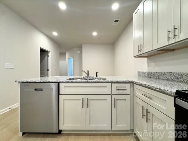 a kitchen with granite countertop white cabinets and white appliances