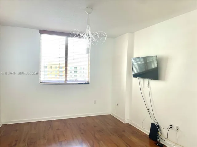 a view of a room with wooden floor and windows