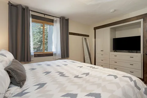 a bed room with a flat screen tv and a bed