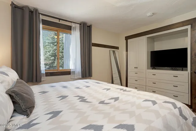 a bed room with a flat screen tv and a bed