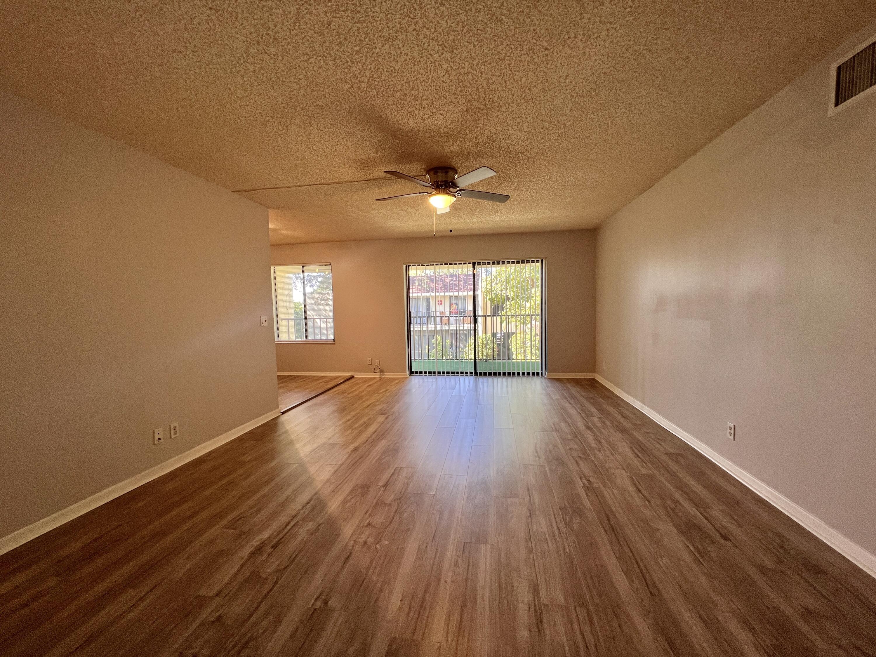 150 Pineview Road, Unit J5 Jupiter, FL 33469 - Photo 11 of 35 wooden floor in an empty room with a window
