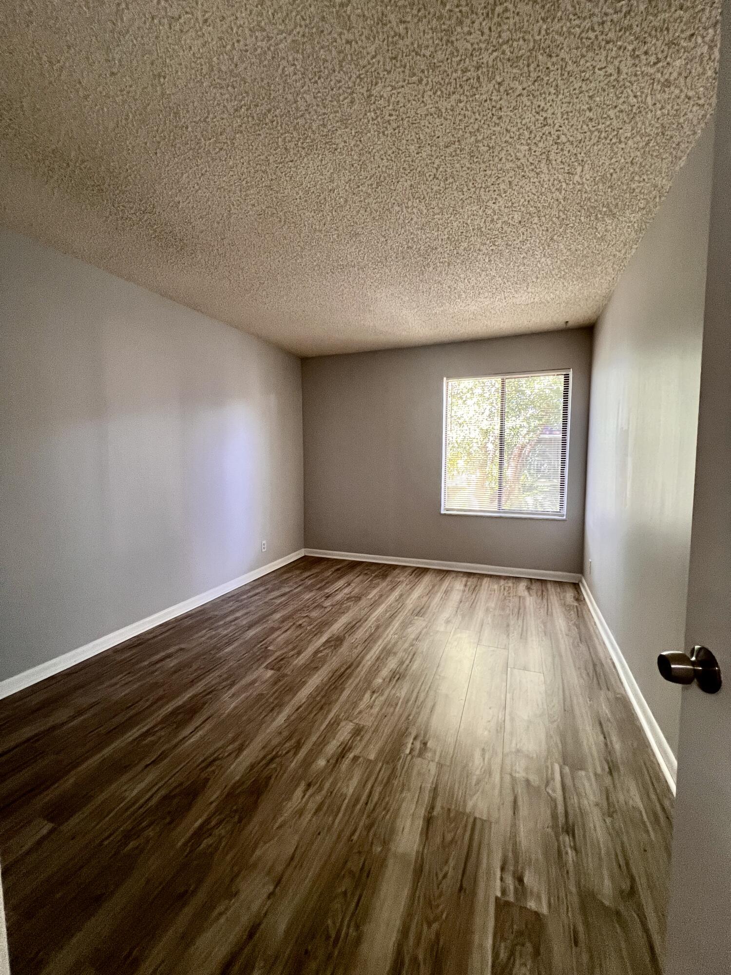 150 Pineview Road, Unit J5 Jupiter, FL 33469 - Photo 14 of 35 an empty room with wooden floor and windows