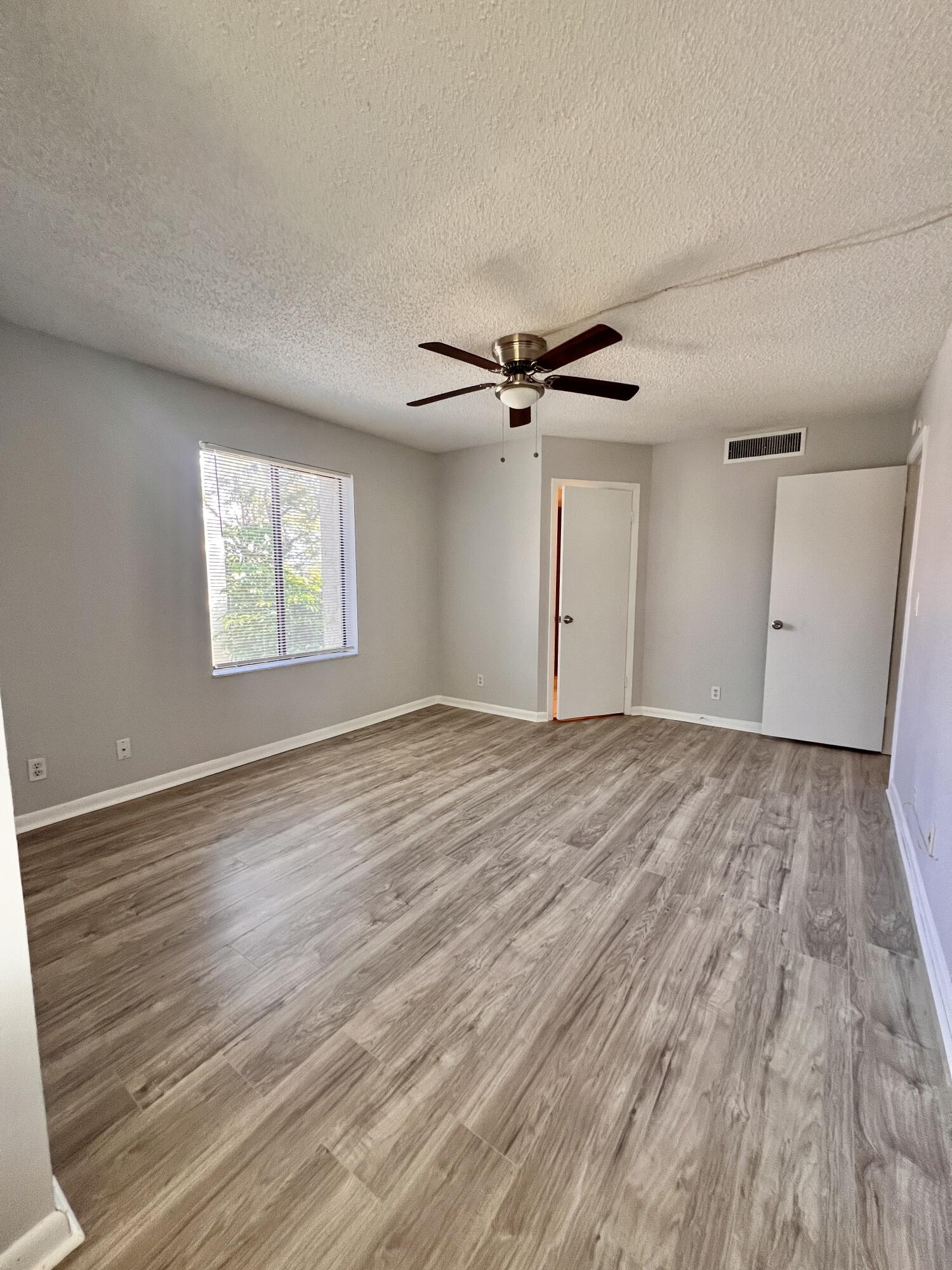 150 Pineview Road, Unit J5 Jupiter, FL 33469 - Photo 17 of 35 wooden floor in an empty room with a window