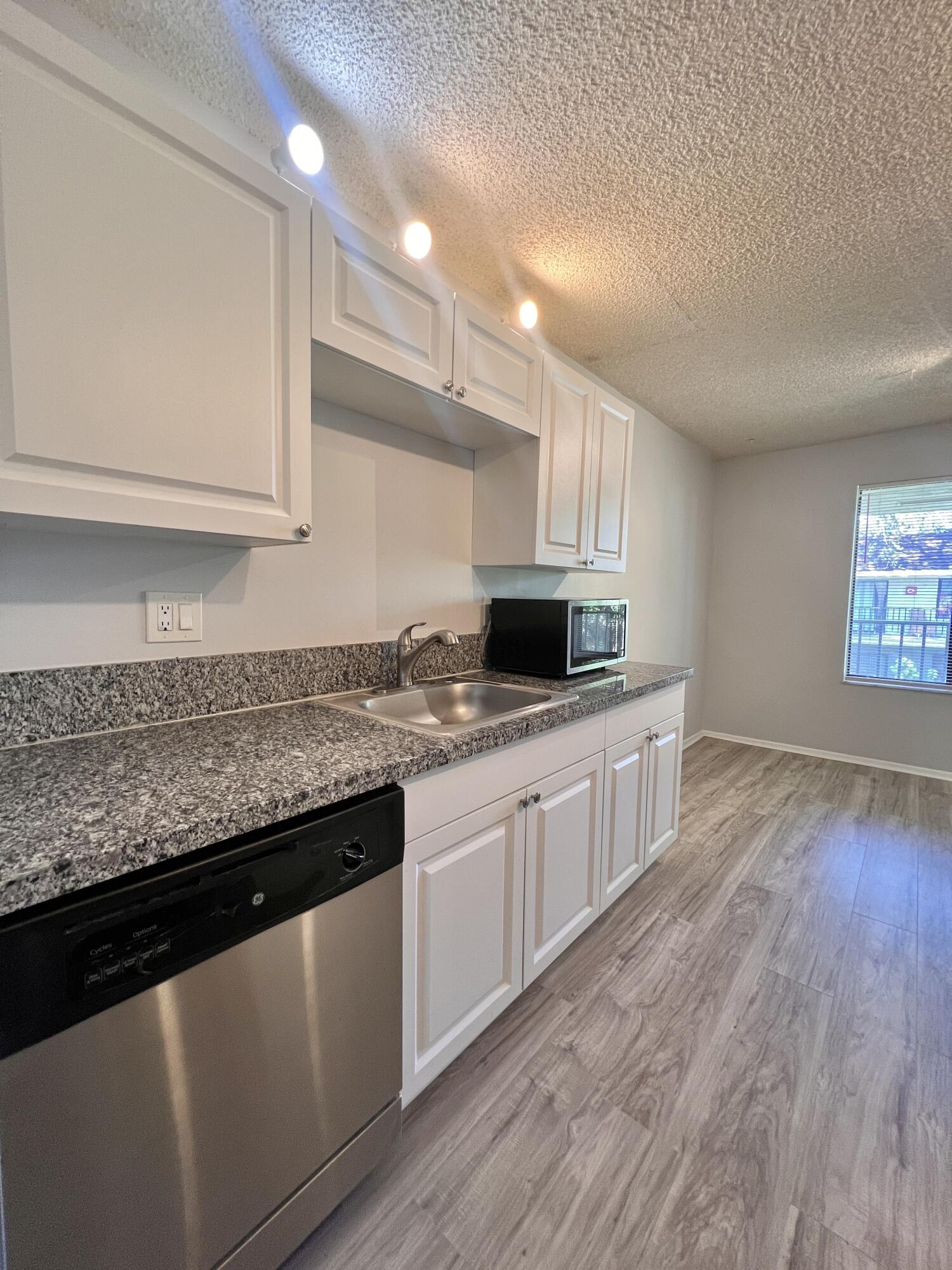 150 Pineview Road, Unit J5 Jupiter, FL 33469 - Photo 3 of 35 a kitchen with granite countertop a sink a stove and cabinets