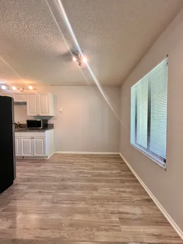 a view of kitchen with granite countertop cabinets and refrigerator