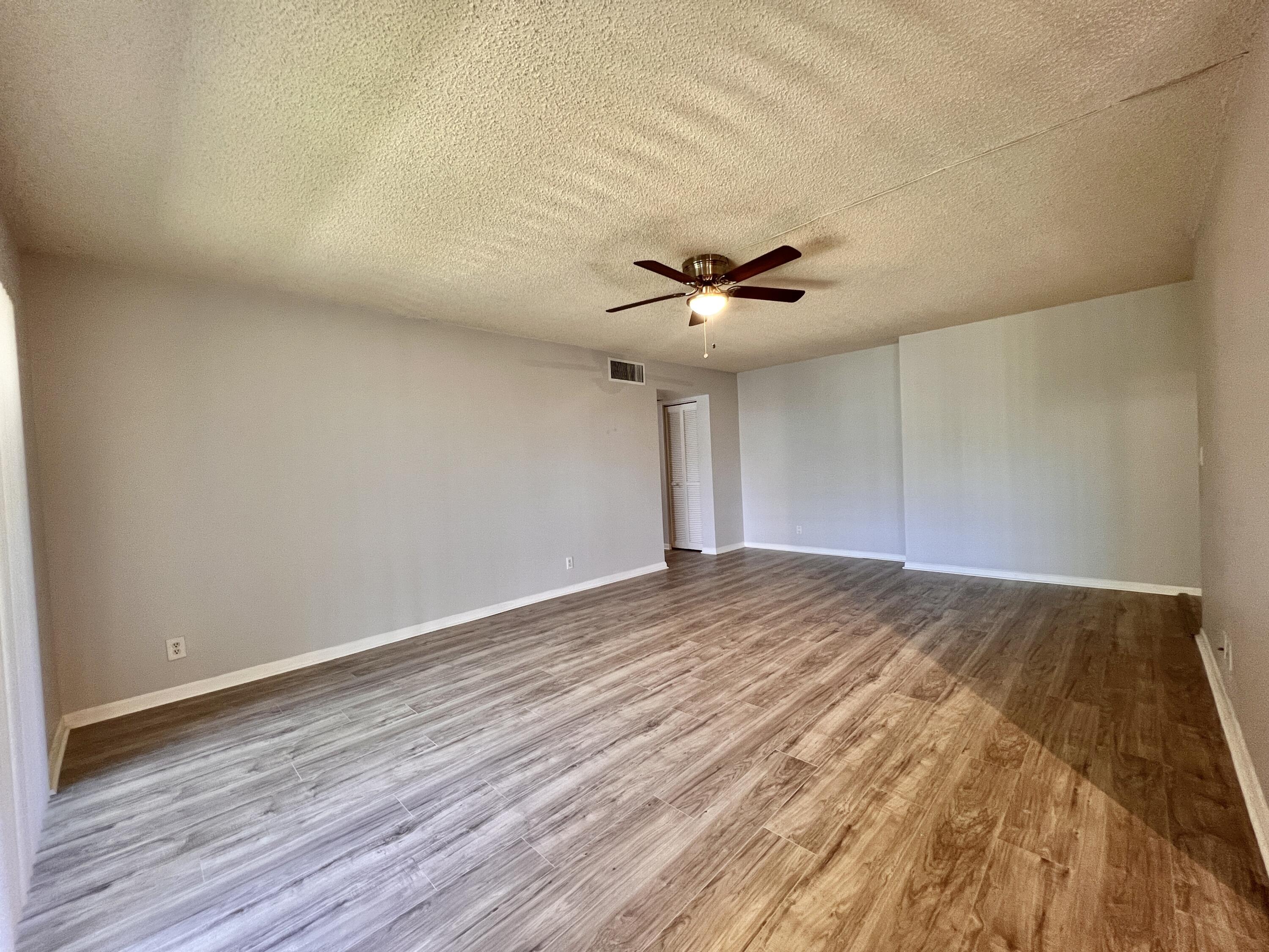 150 Pineview Road, Unit J5 Jupiter, FL 33469 - Photo 9 of 35 a view of empty room with wooden floor and fan