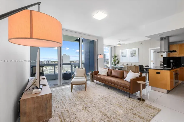 a living room with furniture a fireplace and a floor to ceiling window