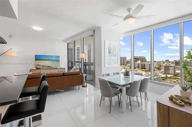 a dining room with furniture a flat screen tv and a large window