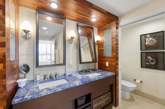 a bathroom with a granite countertop double vanity sink and mirror with bathtub