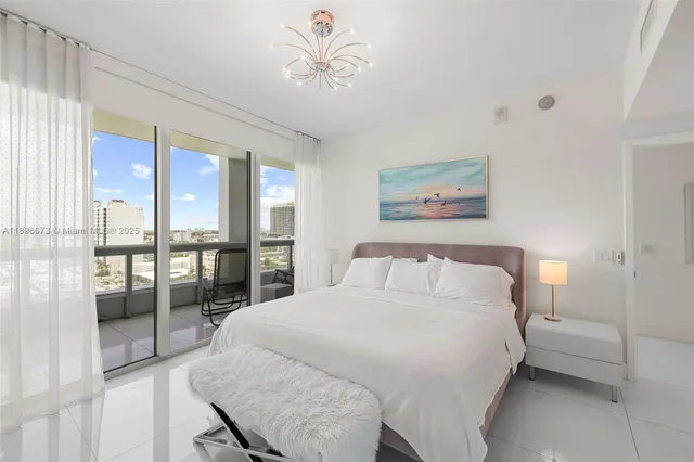 a bedroom with a large bed and a chandelier