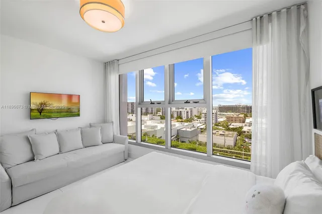 a living room with furniture and a floor to ceiling window