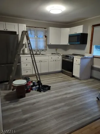 a kitchen with a stove and a wooden floor