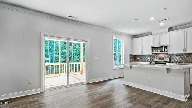 a kitchen with stainless steel appliances a stove top oven a sink a refrigerator a window