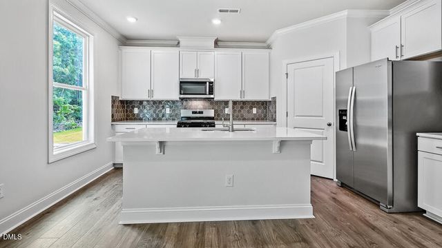 a kitchen with stainless steel appliances a refrigerator sink and microwave