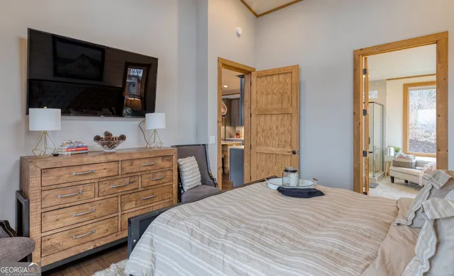 a bedroom with a bed and a flat tv screen on dresser