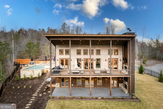 a kitchen with stainless steel appliances granite countertop a stove a refrigerator a kitchen island a couches and chairs with wooden floor