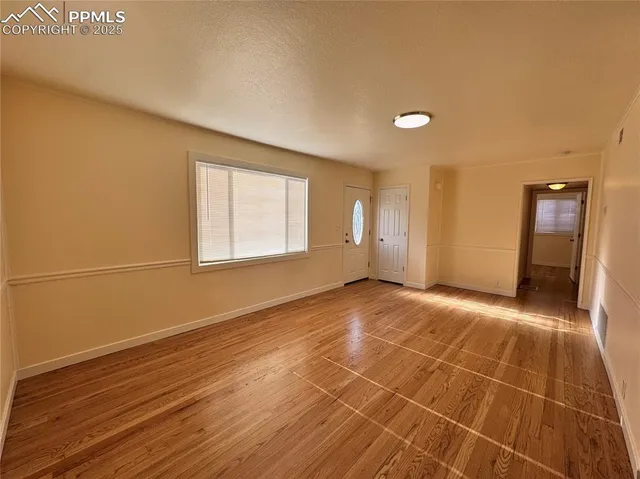 a view of a room with wooden floor and brick walls
