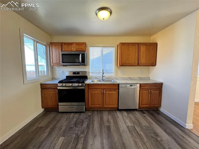 a kitchen with stainless steel appliances granite countertop a sink stove and cabinets