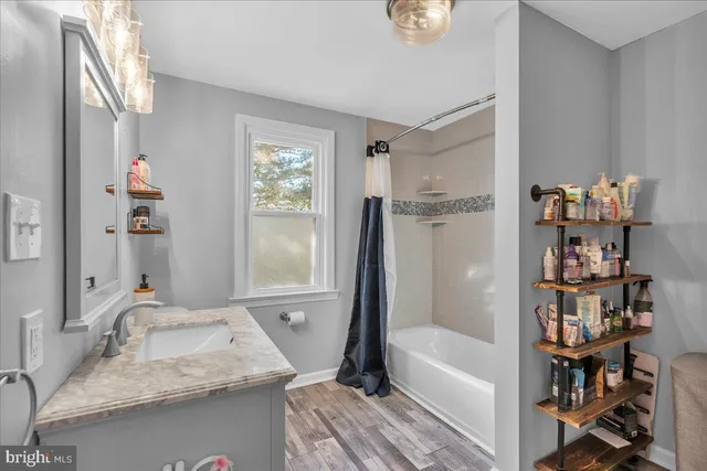 a bathroom with a granite countertop toilet a sink and a large mirror