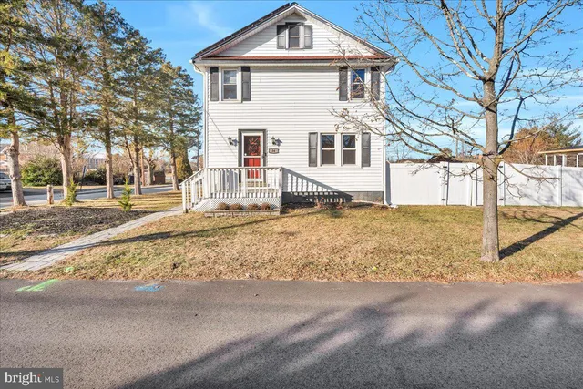 a white house that has a tree in front of it