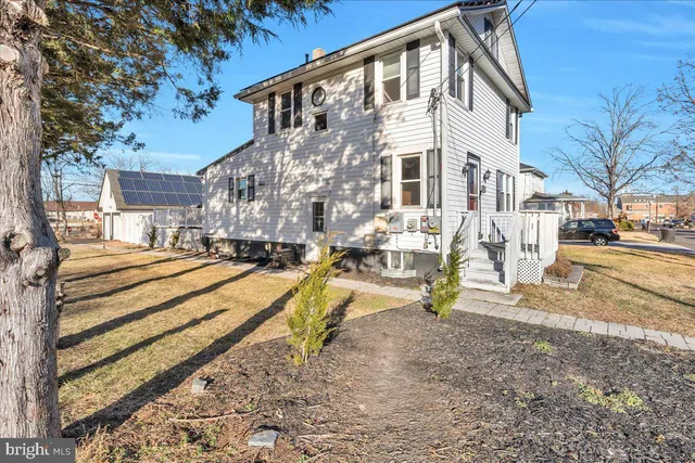a view of residential houses with yard and road