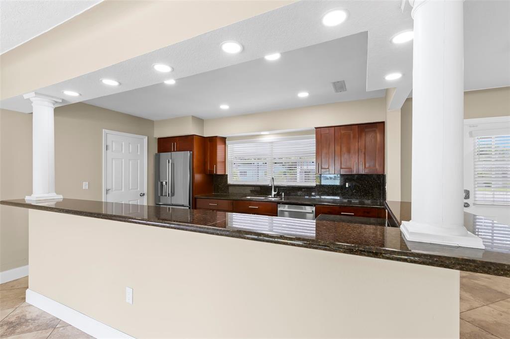 708 Sunset Cove Madeira Beach, FL 33708 - Photo 8 of 61 a large kitchen with stainless steel appliances a large counter top a stove and a sink