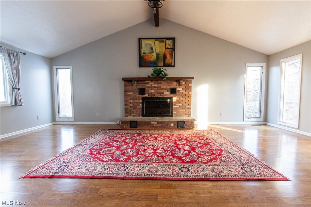 739 Som Center Road Cleveland, OH 44143 - Photo 14 of 36 Unfurnished living room featuring a wealth of natural light, a brick fireplace, and hardwood / wood-style flooring