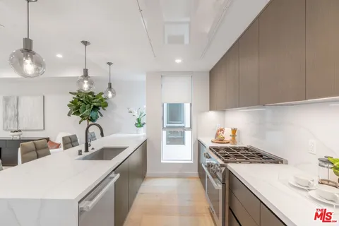a room with a chair and white cabinets