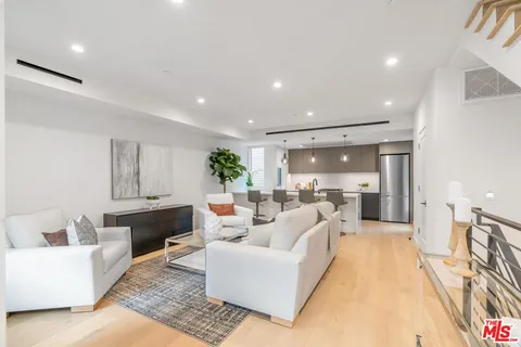a living room with furniture potted plant and a chandelier