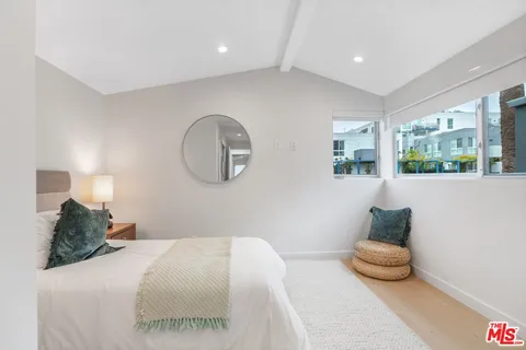 a bedroom with a bed and a mirror