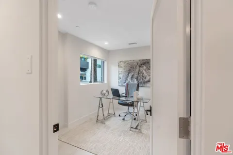 a view of a hallway with chairs and flower pot