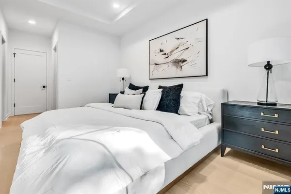 a bedroom with a bed and painting on the wall