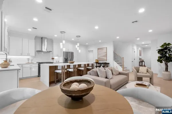 a living room with furniture and a view of kitchen