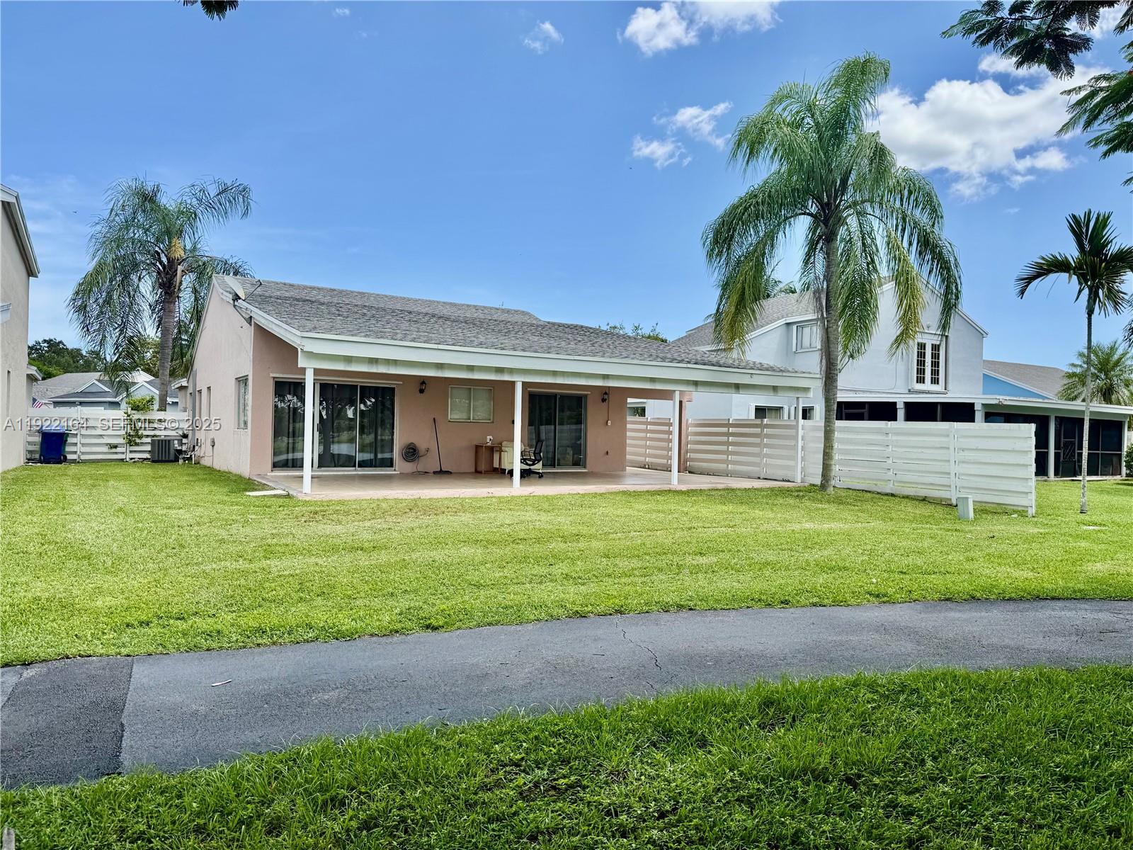 14570 Southwest 145th Place Miami, FL 33186 - Photo 2 of 5 a front view of a house with a garden