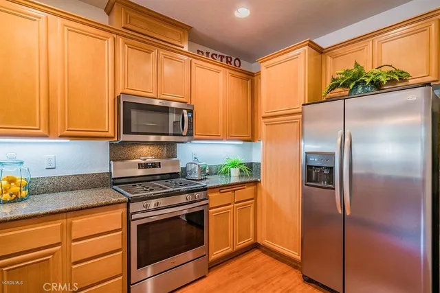a kitchen with stainless steel appliances granite countertop a refrigerator sink and microwave