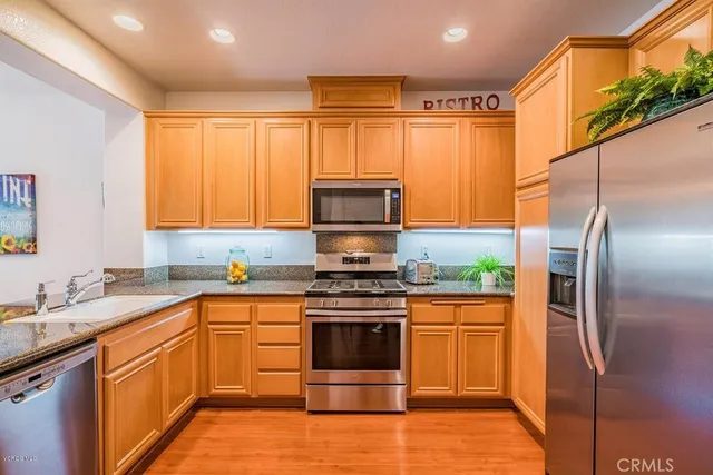 a kitchen with stainless steel appliances a stove sink and refrigerator