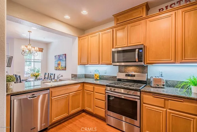 a kitchen with stainless steel appliances granite countertop a sink stove and microwave