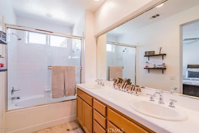 a bathroom with a bathtub shower sink and mirror