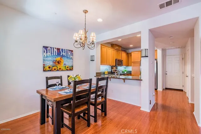 a view of a dining room with furniture a chandelier and wooden floor