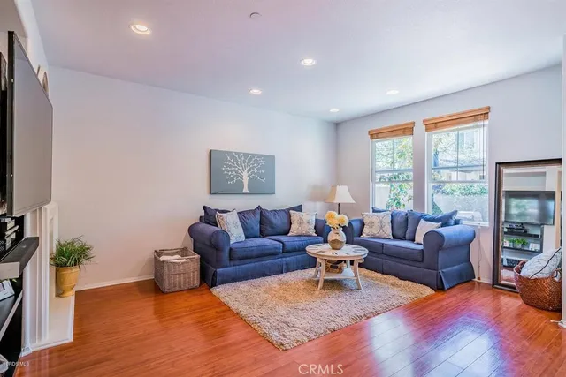 a living room with furniture floor to ceiling window and a flat screen tv