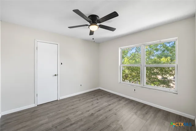 wooden floor in an empty room with a window