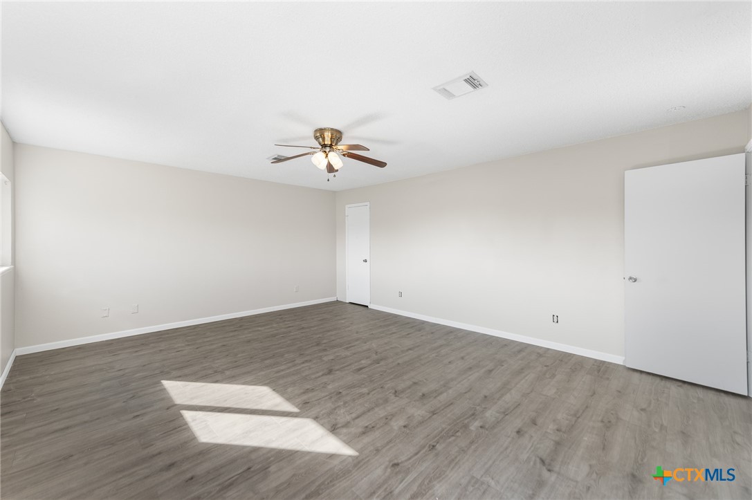 8010 Chestnut Gate Lane Converse, TX 78109 - Photo 19 of 35 an empty room with wooden floor and ceiling fan