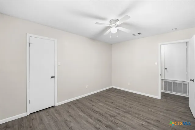 a view of an empty room with wooden floor