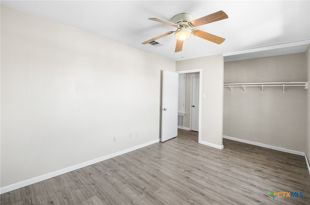 8010 Chestnut Gate Lane Converse, TX 78109 - Photo 26 of 35 an empty room with wooden floor and a ceiling fan